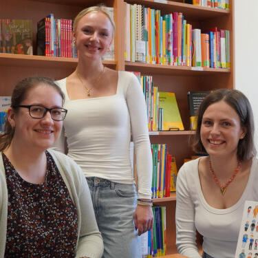 Silvia Vogelsang, Jule Hamacher und Mette Woidtke vor Bücherregal