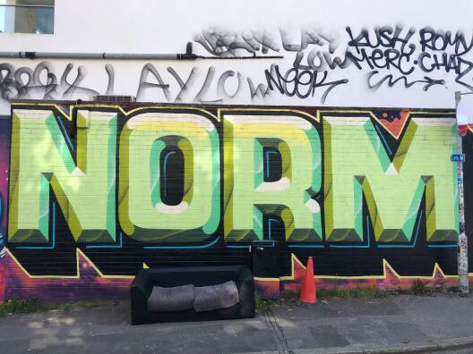 gesprayter Schriftzug "Norm" an einer Wand in Brighton
