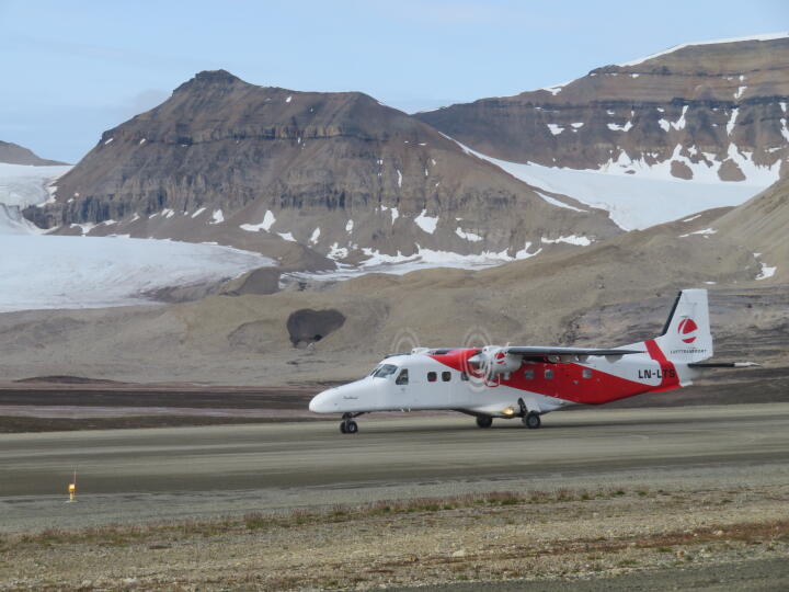 Das Flugzeug aus Longyearbyen ist eben gelandet und wird uns dorthin zurück bringen. Im Hintergrund sieht man einen Schmelzwassertunnel, der die Endmoräne eines Gletschers durchbrochen hat