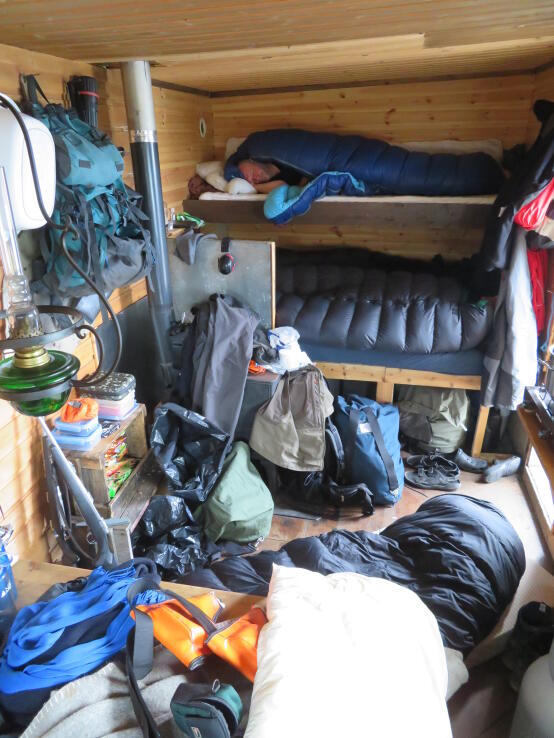 Fünf Leute und Gepäck in einer kleinen Hütte. Schaut unordentlich aus, funktioniert aber