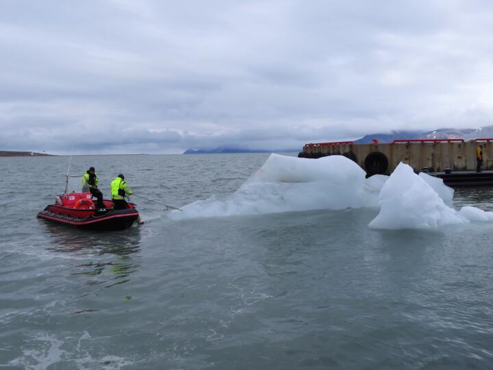 Ein Eisberg blockiert den Hafen und wird weggeschleppt