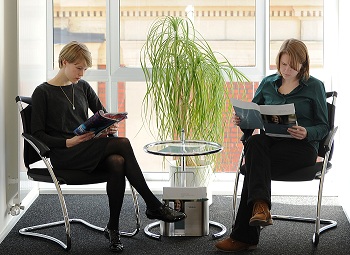 Zwei Frauen lesen im Wartebereich eine Zeitschrift.
