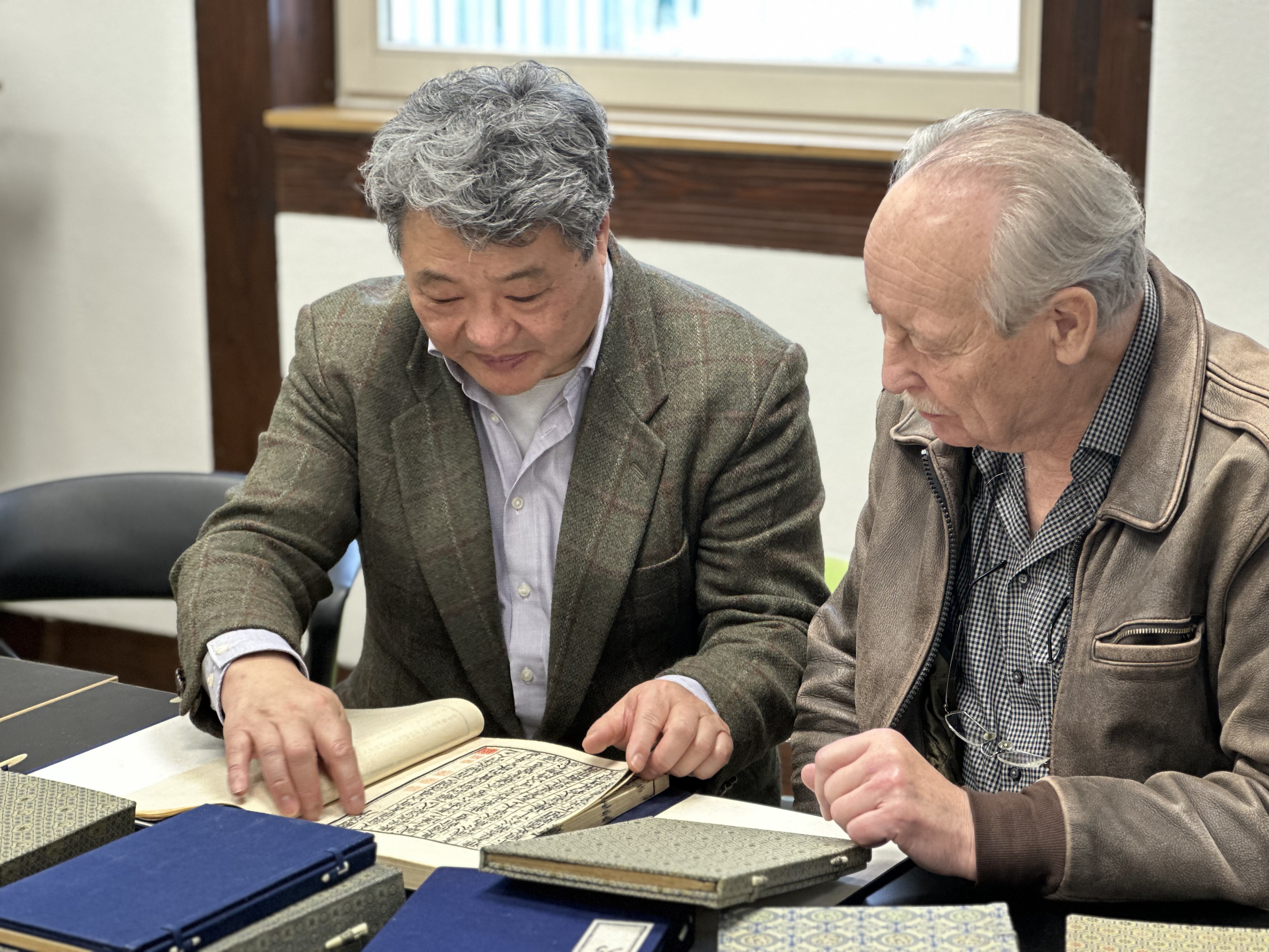 Dr. Yu Hong verschafft sich gemeinsam mit dem Kamener Autor Horst Hensel einen Überblick über die gespendeten Bücher.