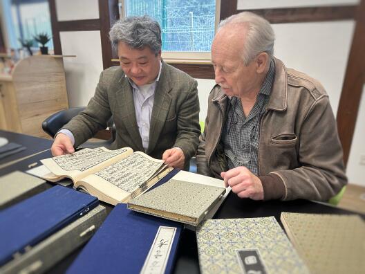 Dr. Yu Hong verschafft sich gemeinsam mit dem Kamener Autor Horst Hensel einen Überblick über die gespendeten Bücher.