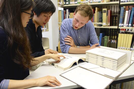 Foto von drei Studierenden beim Lernen in der Bibliothek
