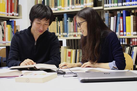Zwei Studierende lernen gemeinsam in der Institutsbibliothek