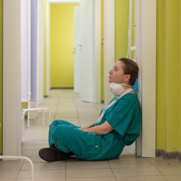 Foto zum Thema: "Kind im blauen kapuzenpulli sitzt auf dem Boden"