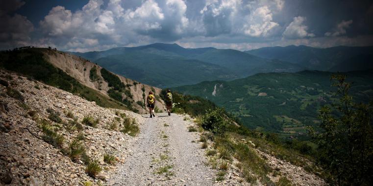 Zwei Stundierende laufen auf einer Schotterstraße am Berg in Piemont, Italien.