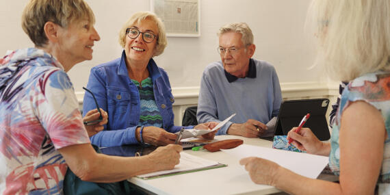 Ältere Studierende arbeiten im Seminar gemeinsam an einer Gruppenarbeit.