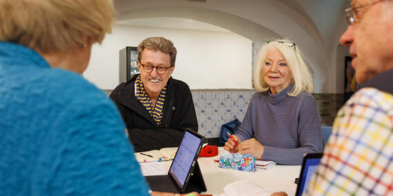 Ältere Studierenden arbeiten und diskutieren im Seminar miteinander.