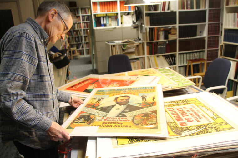 Michael Sondermeyer sichtet die Plakate aus der Sammlung des verstorbenen Klaus Herrmann, die im Dezember 2018 in das Archiv aufgenommen wurden. 