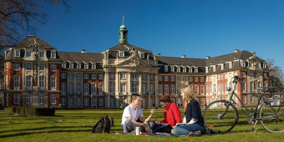 Students sitting in front of the castle