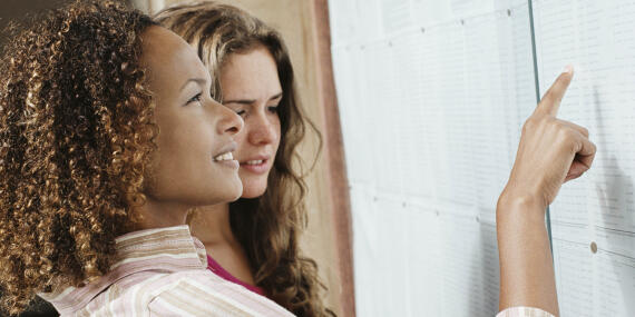 Two women looking at a list