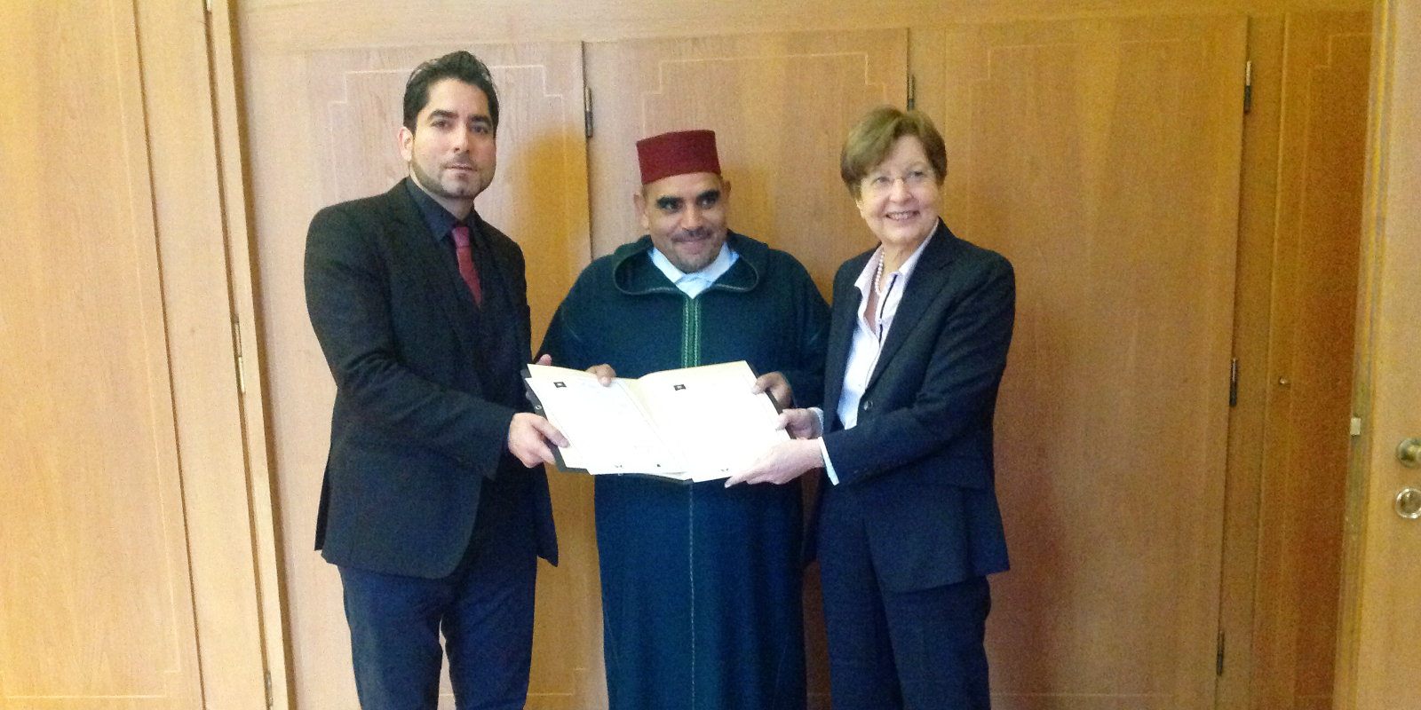 Prof. Dr. Mouhanad Khorchide, Prof. Abdelkader Bettar und Prof.in Dr. Ursula Nelles halten gemeinsam ein Papier in der Hand