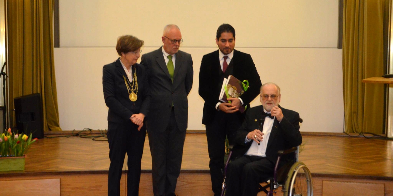 Prof. Dr. Ursula Nelles, Michael Oberkötter und Prof. Dr. Mouhanad Khorchide links stehend neben Muhammad Salim Abdullah im Rollstuhl