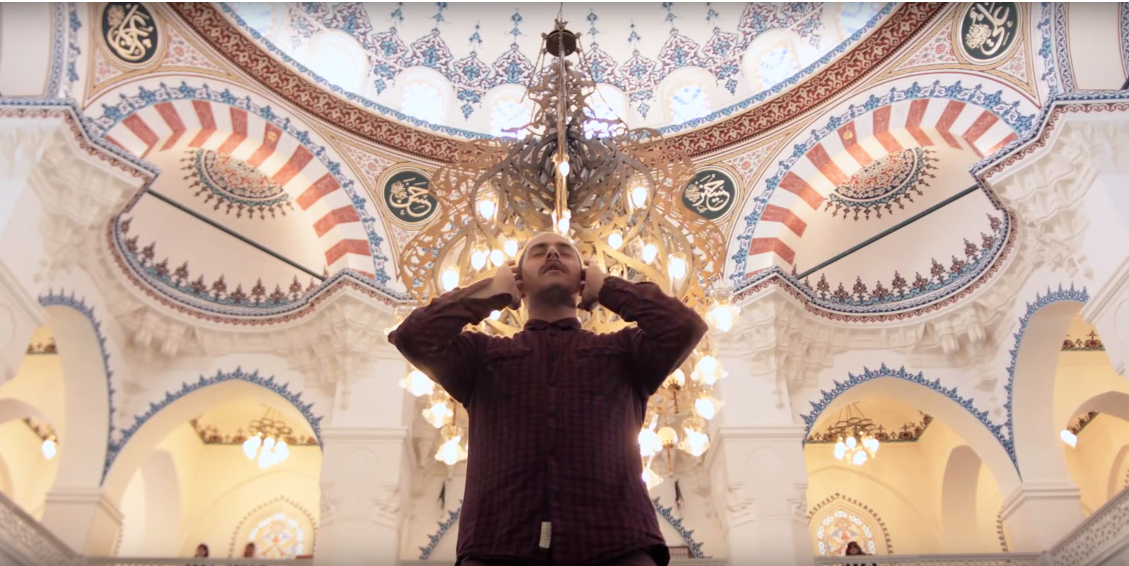 Ein Imam steht unter der Kuppel einer Moschee und ruft aus