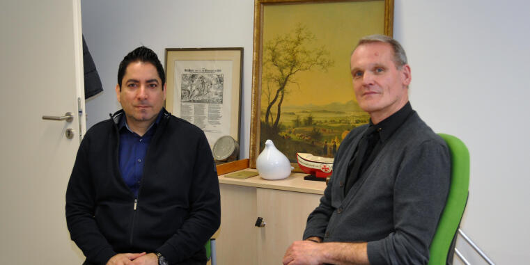 Mouhanad Khorchide und Thorsten Schmidt vom Zentrum für Islamische Theologie sitzen an einem Tisch  im Archiv des ZIT und schauen in die Kamera