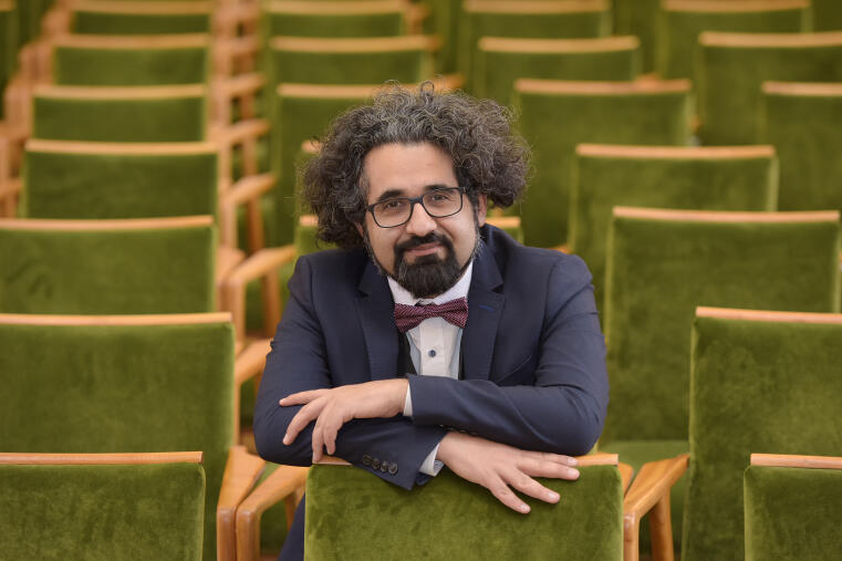 Prof. Dr. Karimi sitzend in mitten von grünen Stühlen