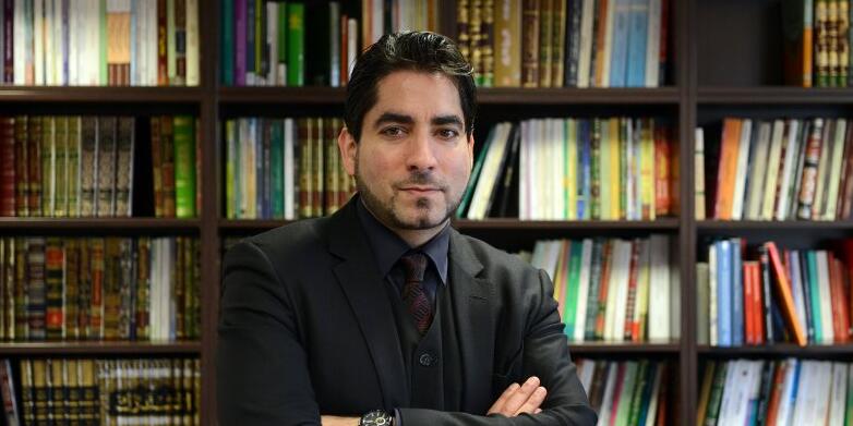 Proträt Prof. Mouhanad Khorchide vor einer Wand mit Büchern