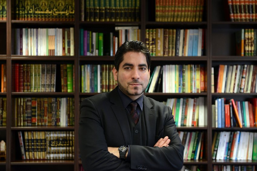 Proträt Prof. Mouhanad Khorchide vor einer Wand mit Büchern