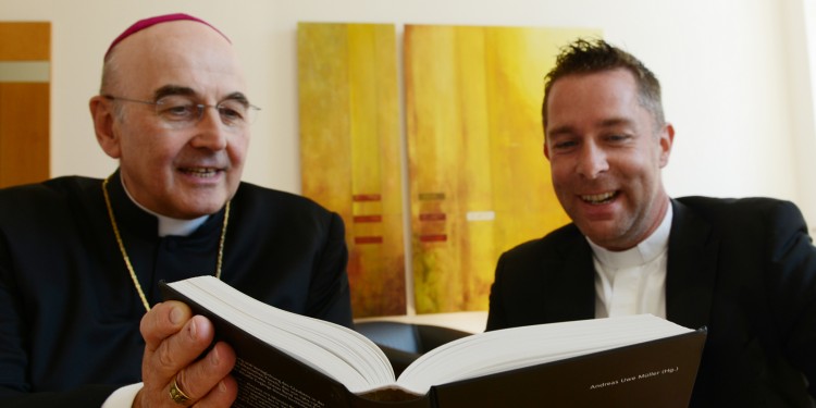 Bischof Felix Genn erhält das Buch "Aggiornamento in Münster. Rückblicke nach vorn" aus den Händen von Dr. Jan Loffeld, wissenschaftlicher Assistent an der Universität Münster<address>&copy; Dialogverlag</address>