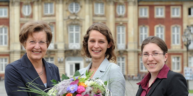 Glückwunsch mit Blumen: Rektorin Prof. Dr. Ursula Nelles (l.) und Nora Kluck (r.), Referentin des Alumni Clubs Münster, begrüßten Tonia Lehmann.<address>&copy; WWU - Peter Grewer</address>