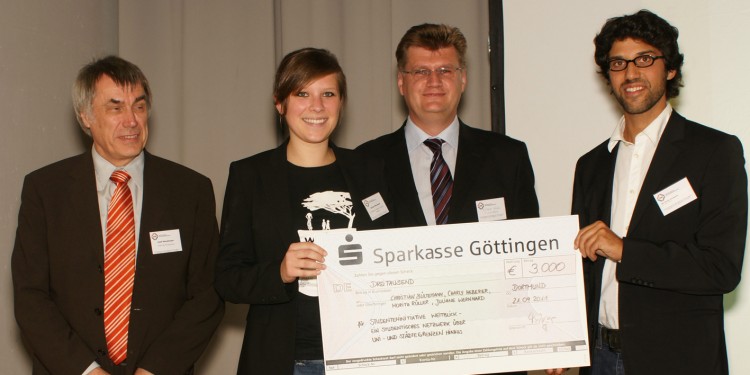 Juliane Wernhard und Niv Nowbakht ("weitblick") nehmen den Scheck über 3000 Euro von Josef Hüvelmeyer (DINI-Vorstand) und Edgar Kühn (Vertreter von T-Systems, Stifterin des Preisgeldes) entgegen.<address>&copy; DINI</address>