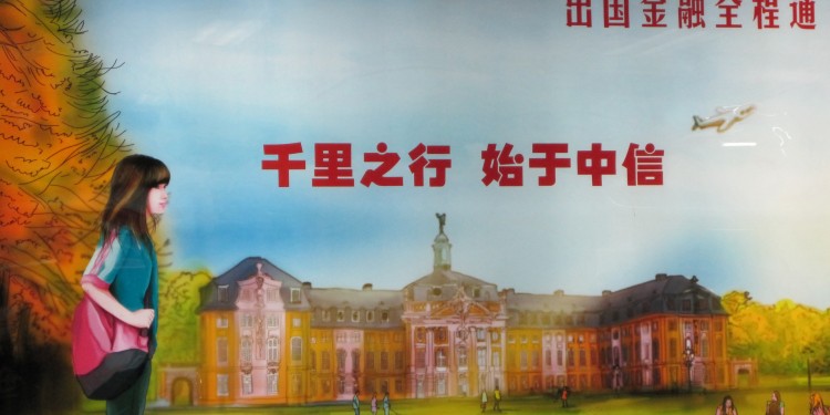 Dieses Werbeplakat einer chinesischen Bank mit dem münsterschen Schloss im Hintergrund hängt in der Pekinger U-Bahn.<address>&copy; WWU</address>