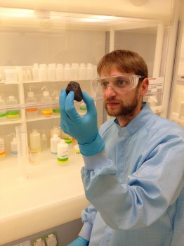 Christoph Burkhardt in the clean room laboratory with a meteorite from the asteroid belt.<address>© WWU/Planetology</address>