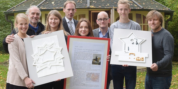 Vertreterinnen und Vertreter des Projektteams mit den Modellen der Zitadelle und des heutigen Schlossgeländes.<address>&copy; WWU/Peter Grewer</address>