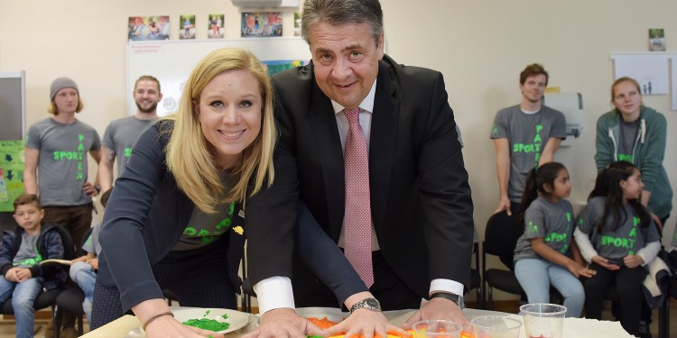 Außenminister Sigmar Gabriel und Marie Ghanbari gestalteten mit Farbe ein Skateboard.<address>&copy; WWU - Peter Grewer</address>