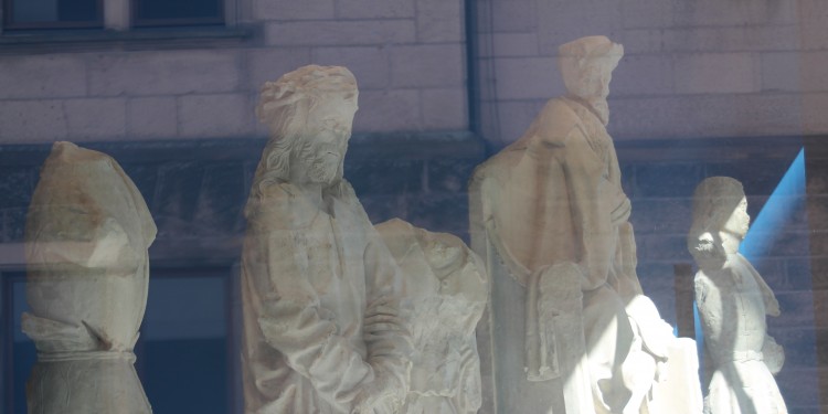 Von den Täufern zerstörte Skulpturen aus dem früheren Portal der Überwasserkirche - heute zu sehen in einem Schaufenster des LWL-Museums für Kunst und Kultur.<address>© WWU - IStG (Ria Hänisch)</address>