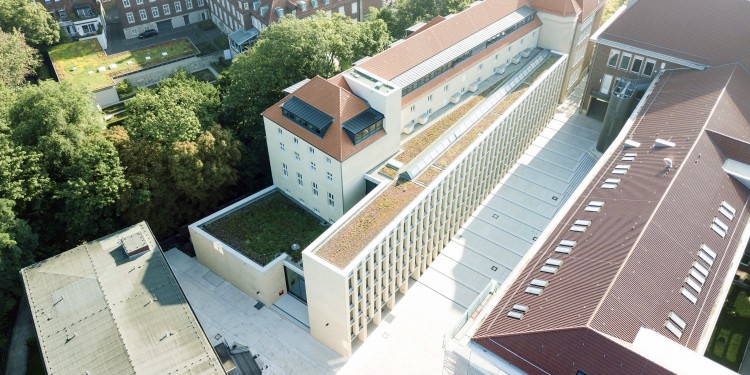 Der Gebäudekomplex aus der Vogelperspektive: Besonders auffällig ist die Fassade des Philosophikums, die Architekt Peter Böhm als „hohe Regalwand“ gestaltet hat.<address>© WWU - Jan Lehmann</address>