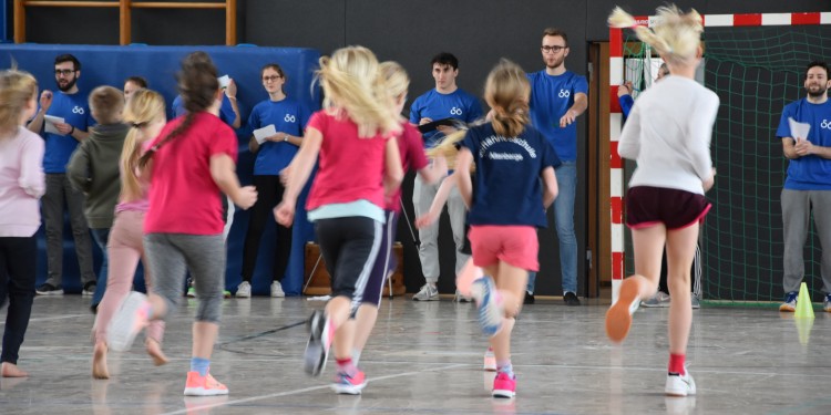 Beim Ausdauertest laufen die Kinder durch die Halle und werden von den Studierenden genauestens beobachtet.<address>&copy; WWU - Kathrin Kottke</address>
