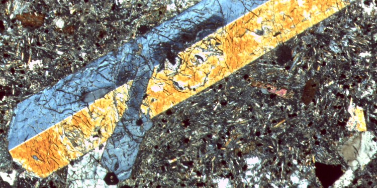 The studied volcanic rock under the microscope: Thin section image in cross polarized light showing clinopyroxene crystals which were used to calculate water concentrations of the magma.<address>© Sarah Mazza</address>