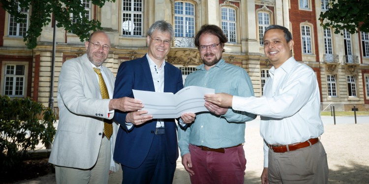 Representatives of both universities with the signed partnership agreement (from left to right): Prof. Dr. Niko Strobach from the Philosophical Seminar of Münster University, Prof. Dr. Michael Quante, Vice-Rector for Internationalization and Knowledge Transfer, Prof. Dr. Raja Rosenhagen and Prof. Dr. Kranti Saran (both Ashoka University).<address>© WWU - MünsterView</address>