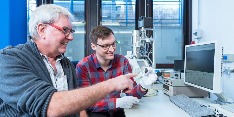 Planetologists Prof. Addi Bischoff (left) and Markus Patzek with the meteorite &quot;Flensburg&quot; in front of the scanning electron microscope.<address>© WWU - Michael C. Möller</address>