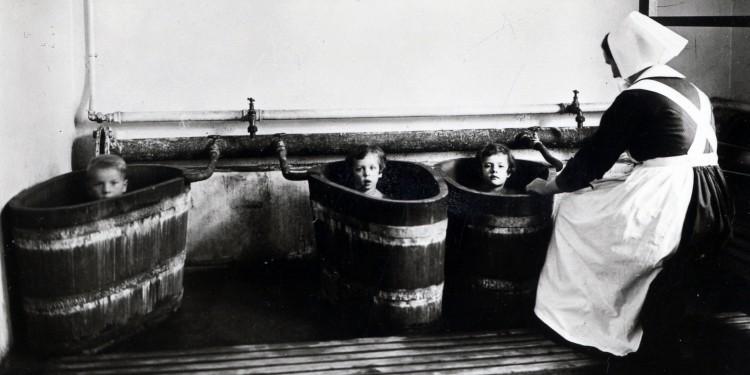 Krankheiten kurieren: Drei Kinder nehmen ein Solebad im Holzbottich.<address>© Westfälische Salzwelten</address>
