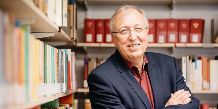 Auf dem Foto ist Prof. Dr. Hans-Peter Großhans vor einem Bücherregal zu sehen.<address>© Bruno Biermann</address>