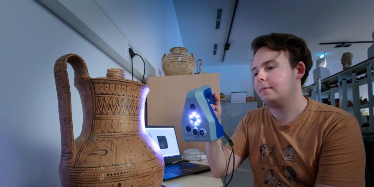 Stück für Stück mit ruhiger Hand und viel Sorgfalt: Silas Pott ist studentische Hilfskraft im Archäologischen Museum der WWU und scannt eine 3.000 Jahre alte Vase ein.<address>© WWU - MünsterView</address>