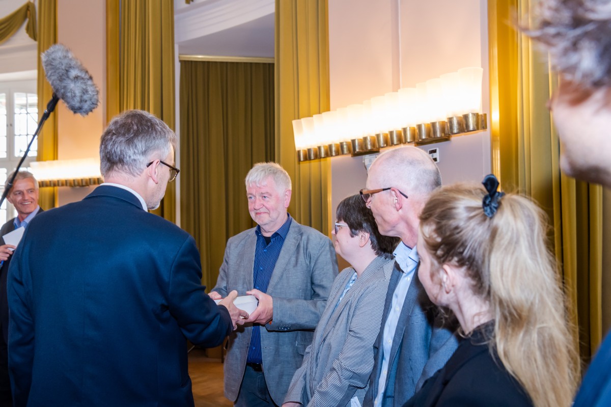 Handing over the book to those affected © WWU - Michael Möller