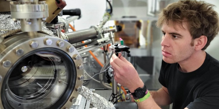 Physicist Paul Möllers prepares the correct positioning of a sample in the vacuum chamber to which the spin polarimeter is connected.<address>© WWU - Tobias Reiker</address>