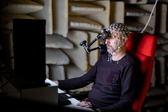 Labor-Ingenieur Andreas Wollbrink zeigt, wie im Akustiklabor mit einem EEG gearbeitet wird.<address>© WWU - Peter Leßmann</address>