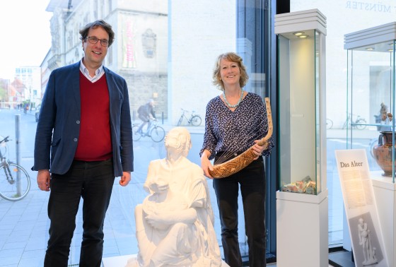 With the “Old Drunkard” – a plaster cast of a marble statue in the Archaeological Museum – and a harp-lute from West Africa, Prof. Achim Lichtenberger and Prof. Dorothea Schulz, the two spokespersons for the “Time and Artefact” Topical Program, show the range of material and non-material objects under investigation.<address>© WWU - Michael C. Möller</address>