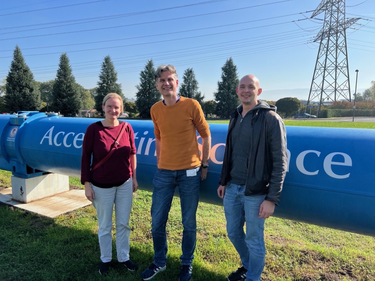 Christian Klein-Bösing (centre), together with two Münster alumni, in front of an LHC magnet at CERN. © privat