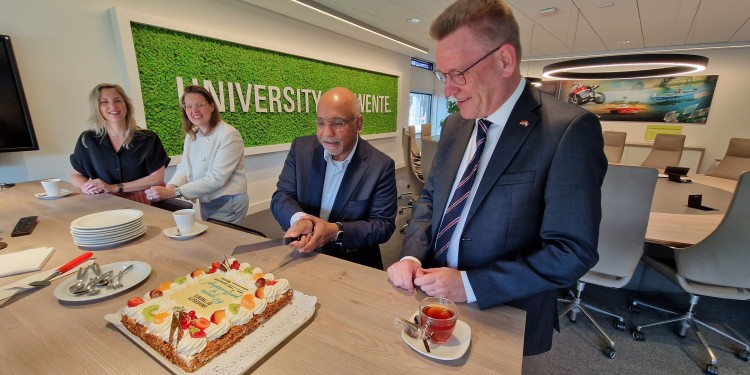 60 Jahre Partnerschaft müssen gefeiert werden. Wie geht das besser als mit einem Sahnekuchen, der die Logos beider Universitäten trägt? Prof. Dr. Vinod Subramaniam (2. v. r.) schneidet für Prof. Dr. Johannes Wessels ein Stück ab.<address>© Universität Twente</address>