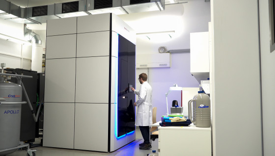 Das Bild zeigt eine große weiße Box. Die Box ist durch eine schwarze Tür zugänglich. Die Technik des Kryo-EM befindet sich innerhalb der Box.<address>© Uni MS - Sophie Pieper</address>