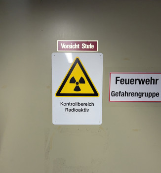 Das Bild zeigt eine Metalltür, auf der ein Schild mit der Aufschrift „Kontrollbereich Radioaktiv“ zu sehen ist.<address>&copy; Uni MS - André Bednarz</address>