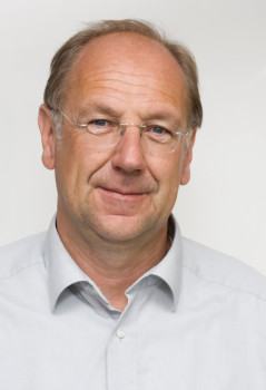 Zu sehen ist ein Porträtfoto von Prof. Dr. Norbert Kersting vor einem hellen Hintergrund.<address>© Anna Overmeyer</address>