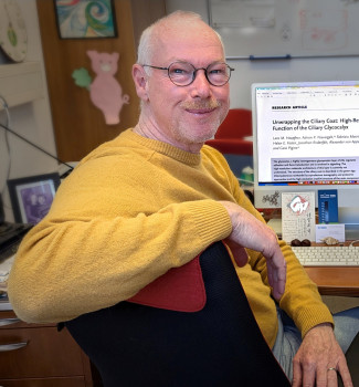 Portrait of Prof. Dr. Michael Hippler (He is sitting in an office chair in front of a monitor and turning towards the photographer).<address>© AG Hippler - Lando Lebock</address>